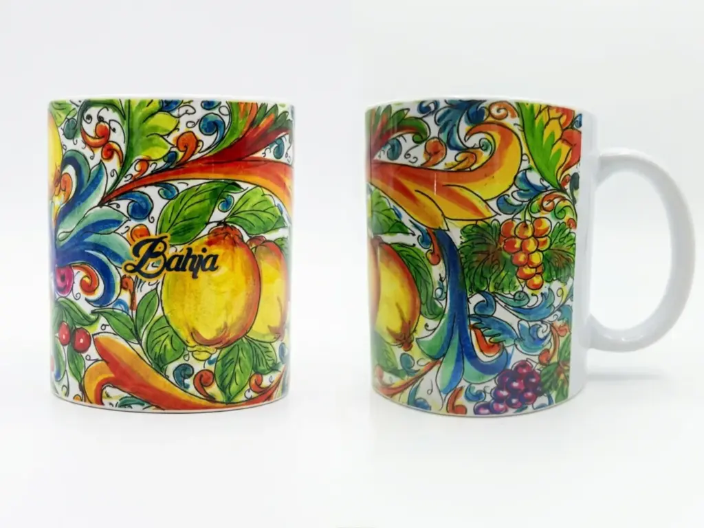 Tazza ceramica bianca: fronte con limoni gialli, arabeschi rosso-arancio e scritta corsiva Bahja; retro con grappoli d'uva viola e volute blu.