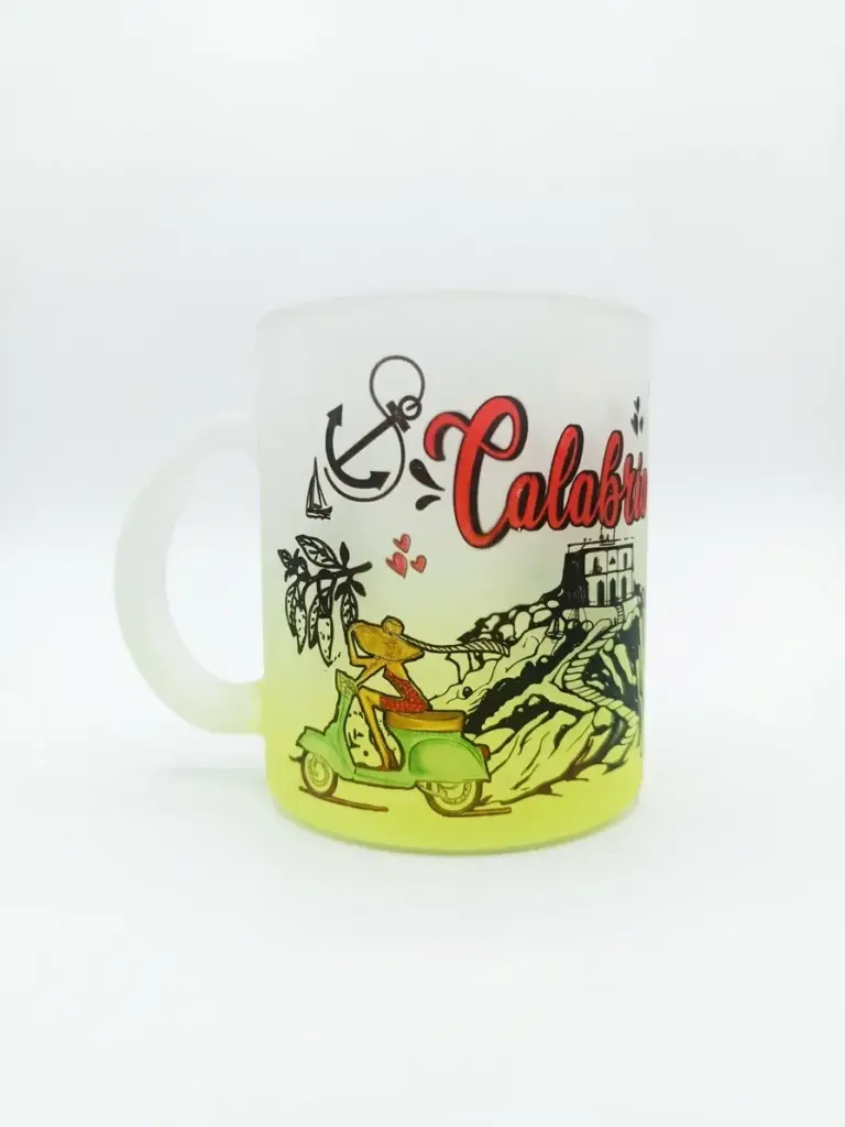 Tazza in vetro satinato con sfumatura gialla, scritta Calabria in rosso corsivo, Vespa verde, ancora nera e edificio costiero su sfondo neutro