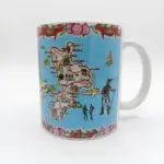 Tazza ceramica bianca con mappa della Calabria su fondo azzurro, bordi con peperoncini rossi e cipolle, figura di brigante e Bronzi di Riace